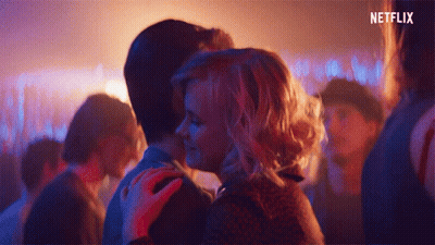 Man And Woman Kissing In Crowd With Netflix Logo GIF