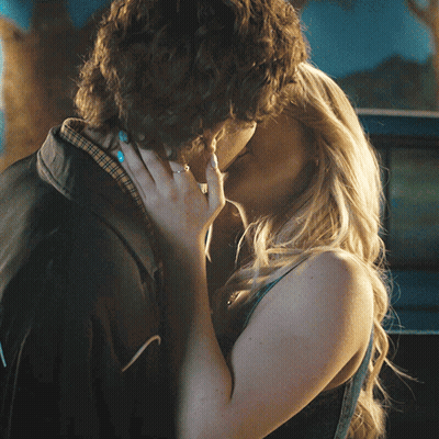 Man And Woman Kissing In Front Of Blue Car GIF