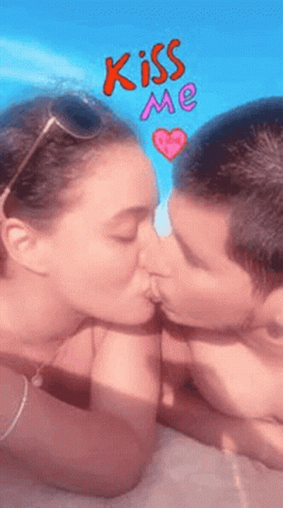 Man And Woman Kissing In Front Of Blue Sky And Pink Heart GIF
