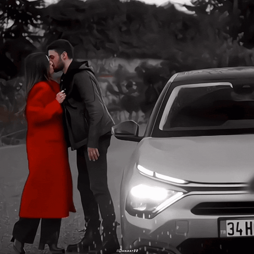Man And Woman Kissing In Front Of Car With 34H License Plate GIF