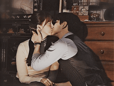 Man And Woman Kissing In Front Of Dresser GIF