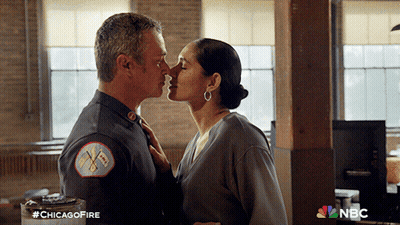 Man And Woman Kissing In Front Of NBC Sign GIF