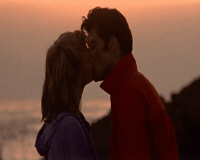 Man And Woman Kissing In Front Of Ocean GIF