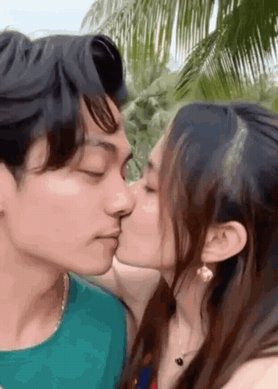 Man And Woman Kissing In Front Of Palm Trees GIF