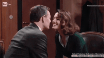 Man And Woman Kissing In Front Of Rai Sign GIF