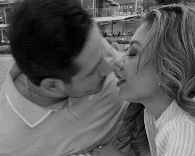 Man And Woman Kissing In Front Of Snow Sign GIF
