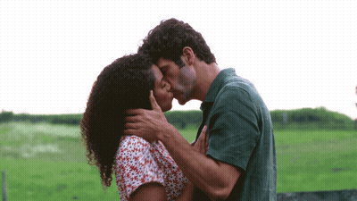 Man And Woman Kissing In Green Field GIF