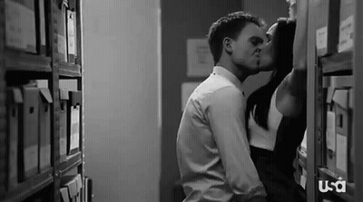 Man And Woman Kissing In Library GIF