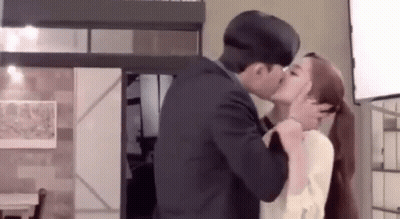 Man And Woman Kissing In Living Room GIF