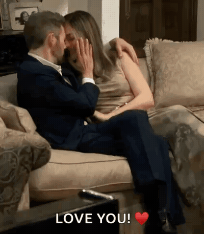 Man And Woman Kissing On Couch Saying Love You GIF