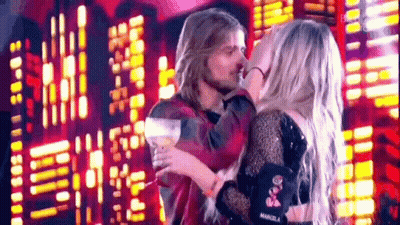 Man And Woman Kissing On Stage In Front Of City Skyline GIF