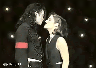 Man And Woman Kissing On Stage In Front Of Crowd GIF