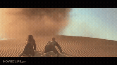 Man And Woman Kneeling In Desert Sand GIF