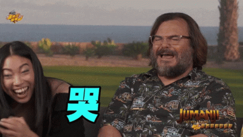 Man And Woman Laughing In Front Of Jumani Poster GIF