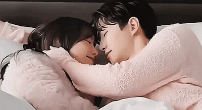 Man And Woman Laying In Bed Hugging GIF