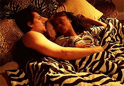 Man And Woman Laying In Bed With Zebra Print Blanket GIF