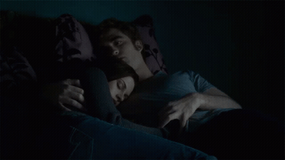 Man And Woman Laying On Couch In Dark GIF