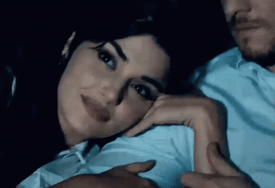 Man And Woman Laying On Couch Woman Looking At Camera GIF