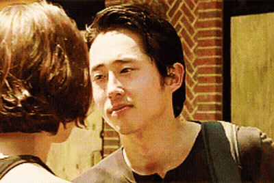Man And Woman Looking At Each Other By Brick Wall GIF