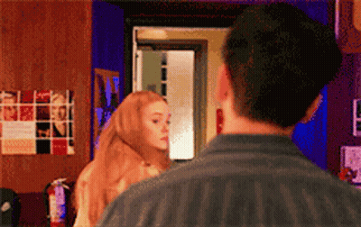 Man And Woman Looking At Each Other In Front Of Fire Extinguisher GIF