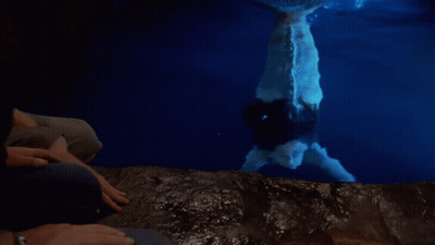 Man And Woman Looking At Mermaid In Water GIF
