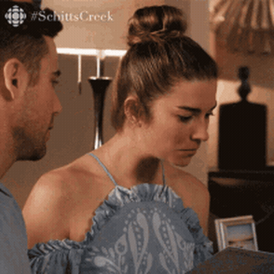 Man And Woman Looking At Schitts Creek GIF