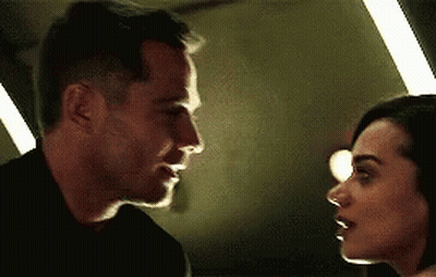 Man And Woman Looking Into Each Other's Eyes In Dark Room GIF