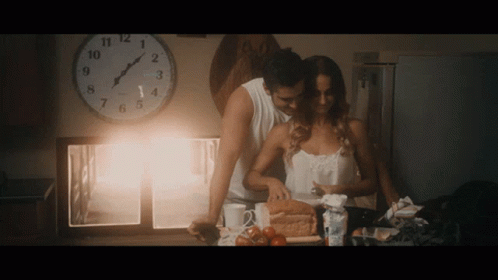 Man And Woman Near Clock Showing Almost 5 GIF
