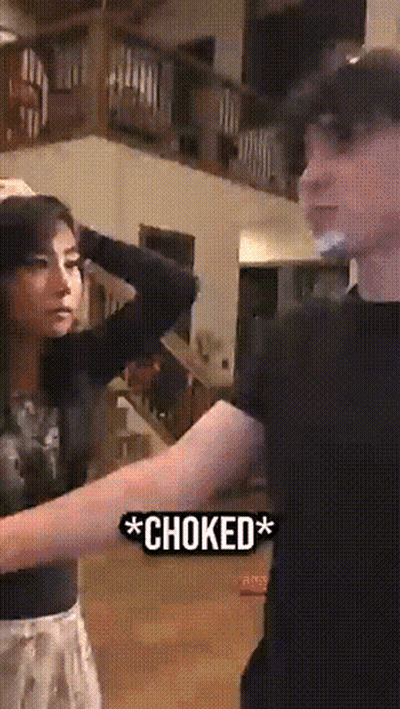 Man And Woman Next To Choked Sign GIF