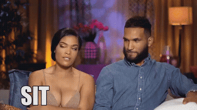 Man And Woman On Couch Woman Saying Sit GIF