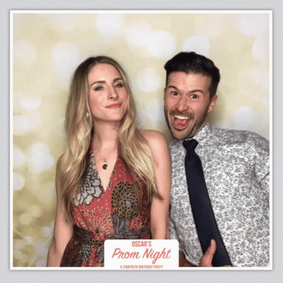 Man And Woman Pose In Front Of Prom Night Photo Booth GIF