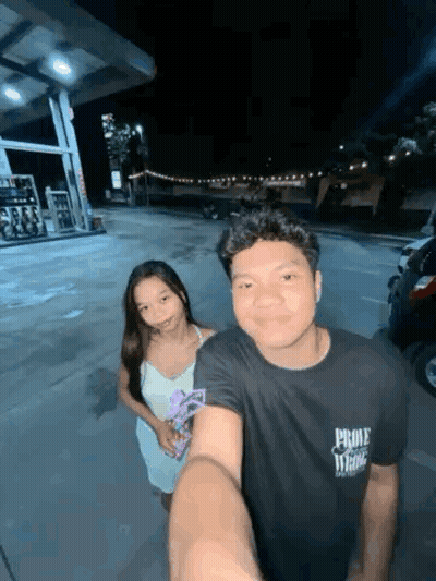 Man And Woman Posing For Selfie At Gas Station GIF