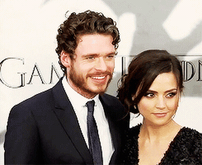 Man And Woman Posing In Front Of Game Sign GIF