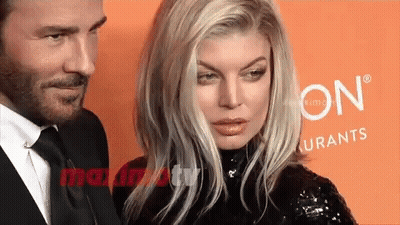 Man And Woman Posing In Front Of Sign GIF