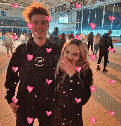 Man And Woman Posing With Pink Hearts GIF