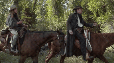 Man And Woman Riding Horses In Forest GIF