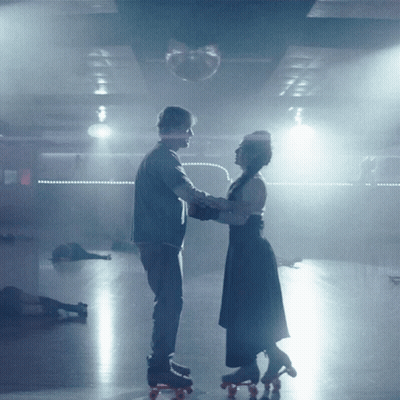 Man And Woman Rollerblading In Dark Room GIF