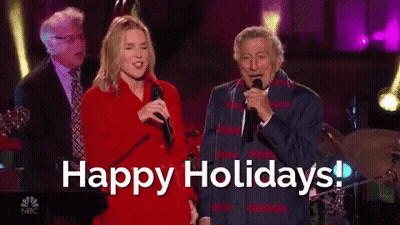 Man And Woman Singing Into Microphones Happy Holidays GIF