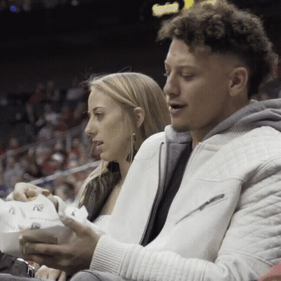Man And Woman Sitting At Basketball Game Man In White Jacket GIF