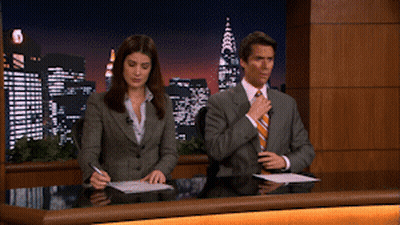Man and Woman Sitting at Desk in Front of City at Night
