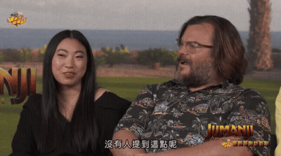 Man And Woman Sitting At Jumani Sign GIF