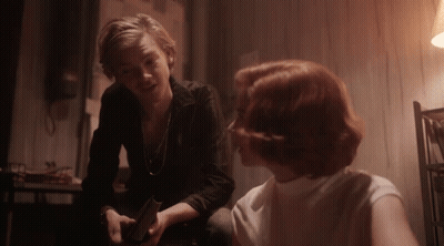 Man And Woman Sitting At Table Looking At Each Other GIF