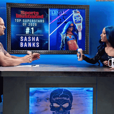 Man And Woman Sitting At Table Under Sasha Banks Picture GIF
