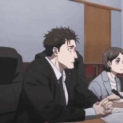 Man and Woman Sitting at Table With Hands Folded