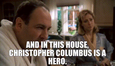 Man And Woman Sitting At Table With House And Columbus Text GIF