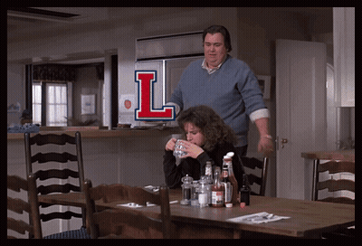 Man And Woman Sitting At Table With Letter L GIF