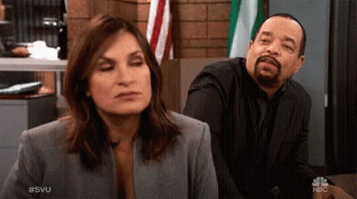 Man And Woman Sitting At Table With NBC GIF