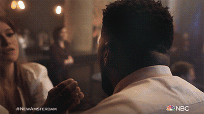 Man And Woman Sitting At Table With NBC GIF