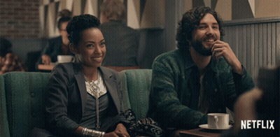 Man And Woman Sitting At Table With Netflix Logo GIF