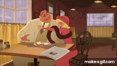 Man And Woman Sitting At Table With Newspaper GIF